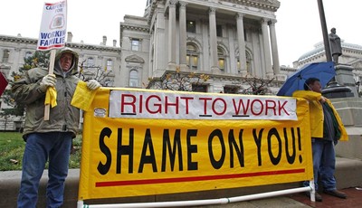 
              FILE - In this Nov. 22, 2011, file photo, Joe Lubbers, left, and Rick McKee display a sign in front of the Statehouse before start of Organization Day in Indianapolis. Union members ral